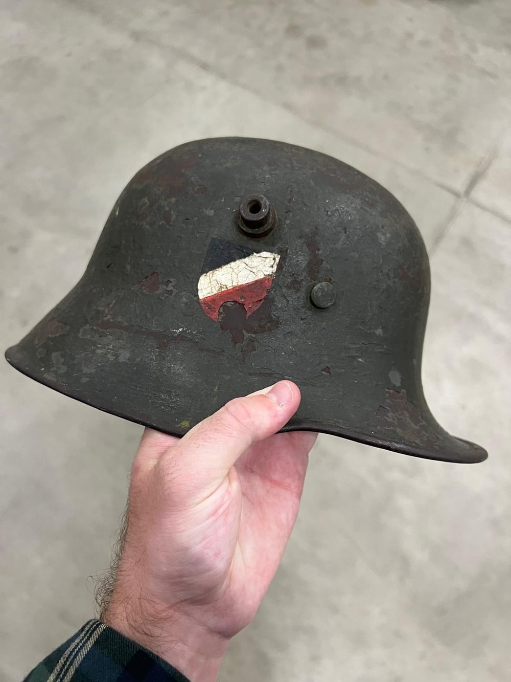 Casco alemán de la Primera Guerra Mundial, con los tetones de ventilación a los lados y un escudo tricolor pintado encima, sin restaurar.