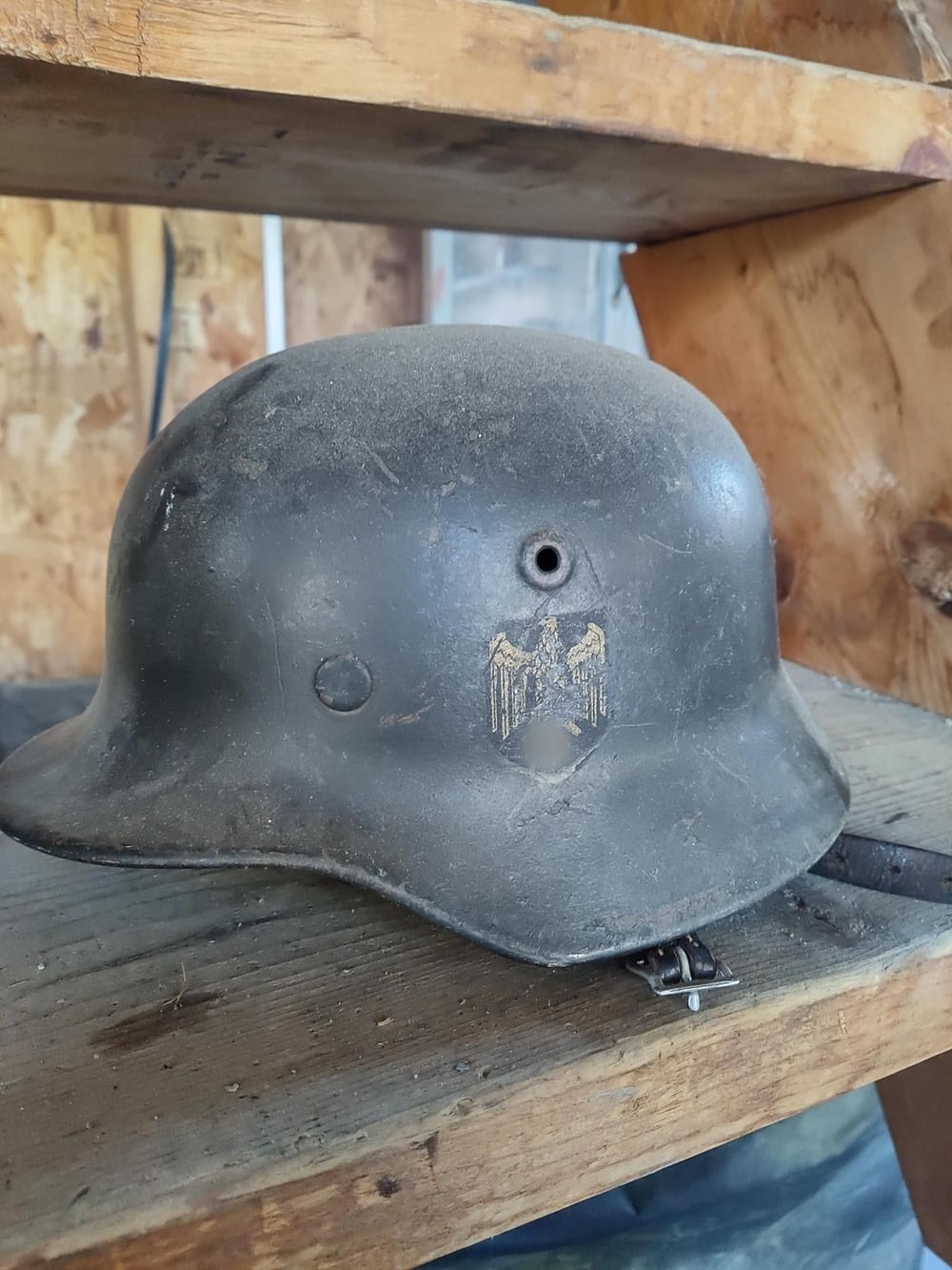 Casco M40 de perfil, con el barbuquejo puesto y la calcomanía del Heer todavía legible. El símbolo de debajo va tapado (§ 86a StGB).