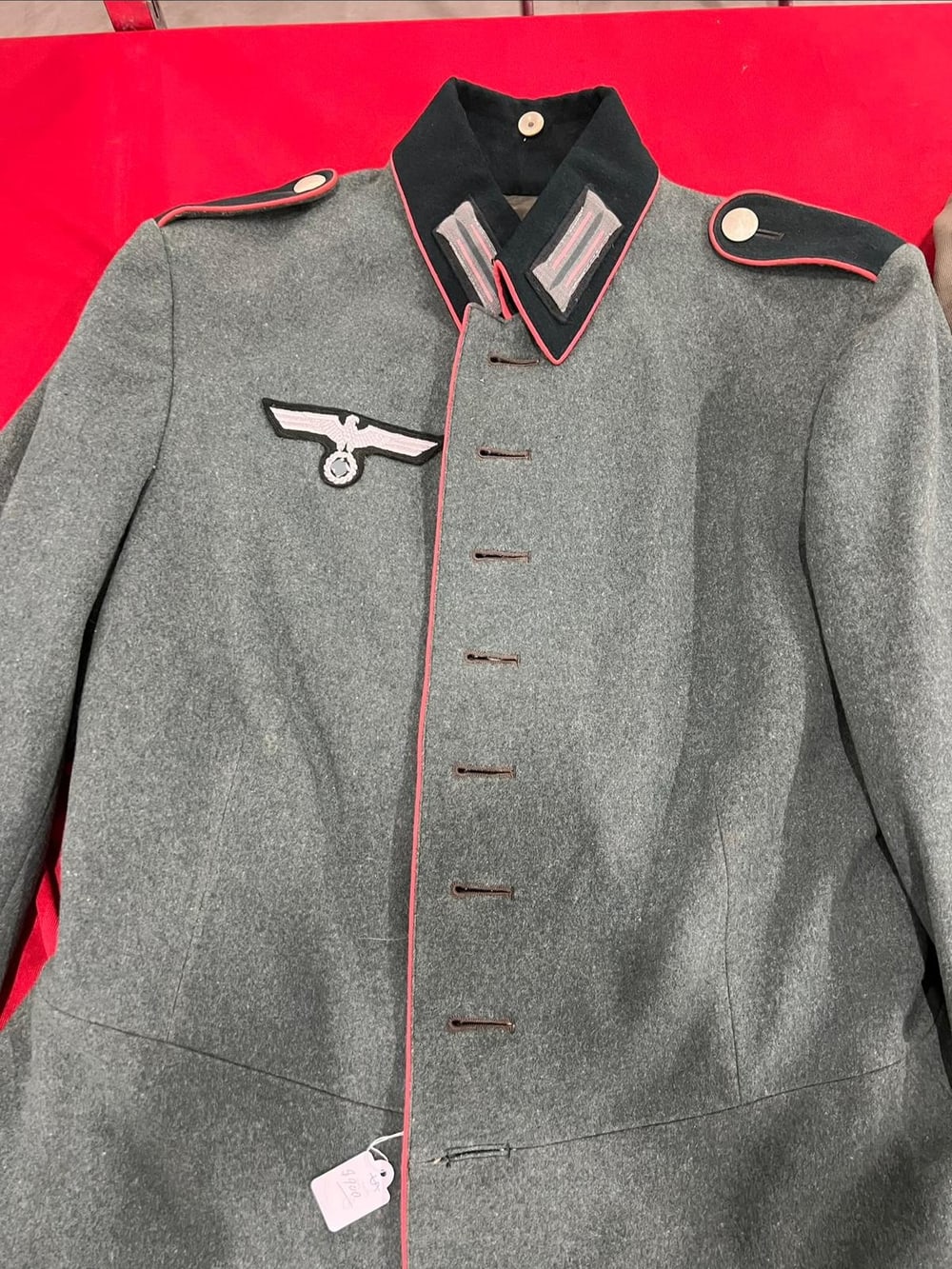 Guerrera de artillería de la Wehrmacht: vivos rojos en el cuello, las hombreras y la botonadura. El símbolo del águila va tapado (§ 86a StGB).