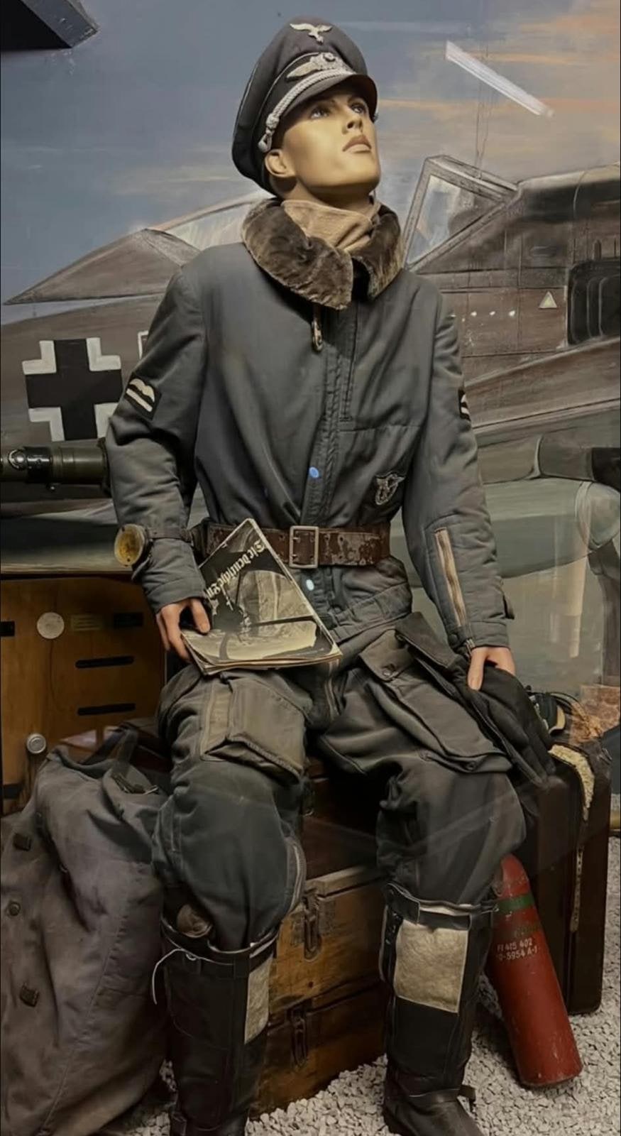 Mono de vuelo forrado con cuello de piel, botas altas y cartera de mapas.